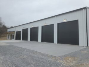 A commercial building featuring multiple black garage doors installed by 314 Overhead Doors in O'Fallon, MO.