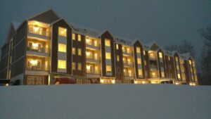 A large commercial building illuminated at night, showcasing exterior lighting installed by Greif Electric Company in Dolgeville, NY.