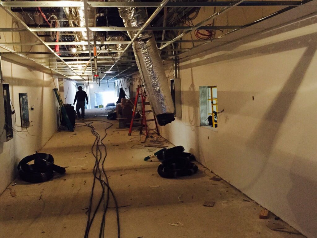 Commercial hallway under construction with exposed ceiling framework and cabling rough-in by D & D Cabling Solutions in Arlington, TX.