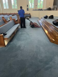 A professional performing commercial carpet cleaning in a church by Word of Mouth Cleaning Services in Houston, TX.