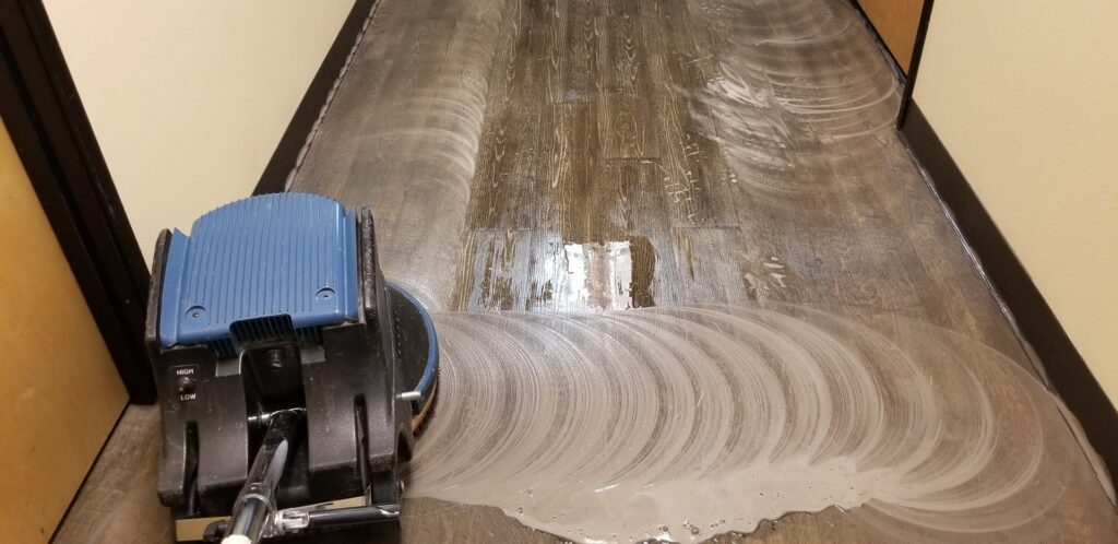 Commercial carpet cleaning in progress with a machine, showing a clean path by Foothills Steam Carpet Cleaners in Fort Collins, CO.