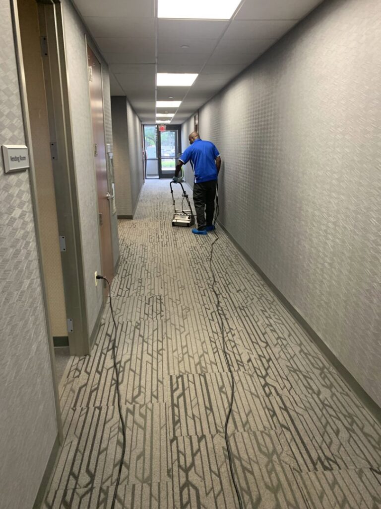 A professional cleaning a commercial hallway carpet with a machine by Elite Clean Steamers in Indianapolis, IN