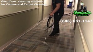 A professional cleaning technician performing commercial carpet cleaning in a hallway for Fantastic Carpet Cleaning NYC in Ridgewood, NY