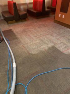Commercial carpet cleaning in progress, showing hoses and a partially cleaned area by Chem-Dry of Sioux Falls in Sioux Falls, SD.