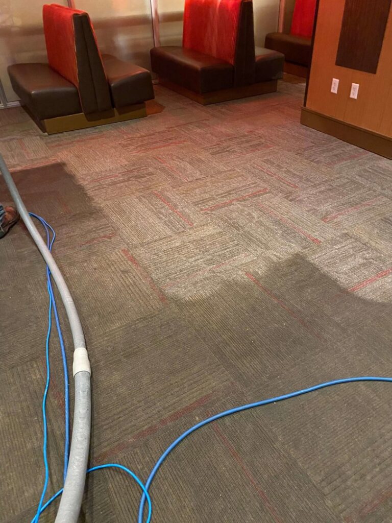 Commercial carpet cleaning in progress, showing hoses and a partially cleaned area by Chem-Dry of Sioux Falls in Sioux Falls, SD.