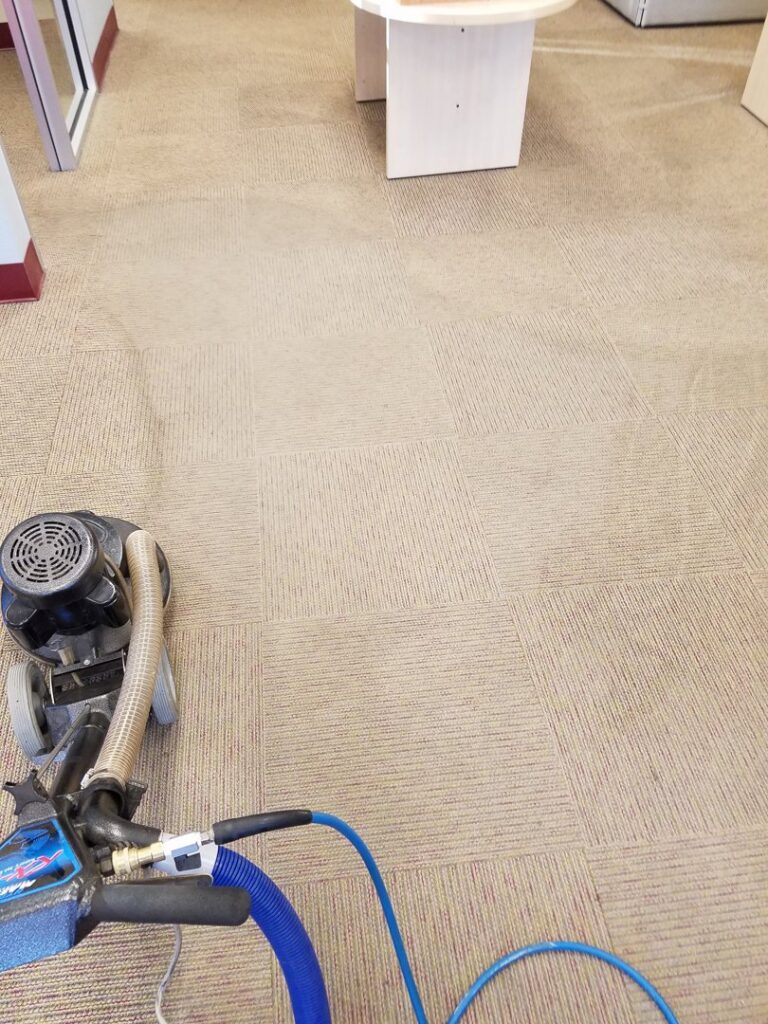 A professional carpet cleaning machine working on a commercial carpet, demonstrating services by Exceptional Carpet Care in Rochester, MN.