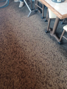 A professional carpet cleaning tool in use on a patterned commercial carpet by Hopman Rug Cleaners in Hammond, IN.