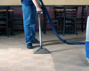 A professional performing commercial carpet cleaning services for a business by Jay Dee Inc. in Denver, CO.