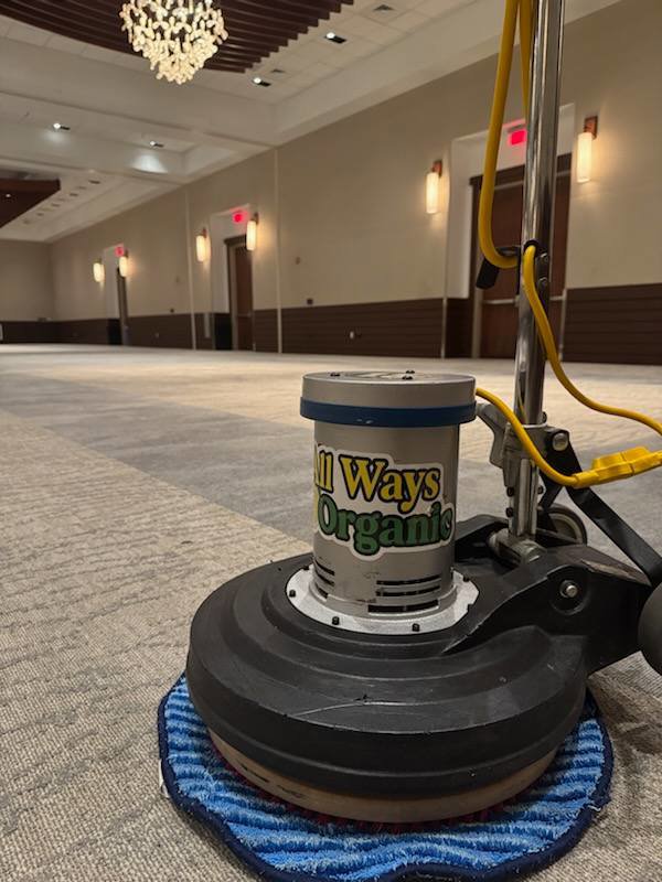 A professional carpet cleaning machine ready for a commercial job in a large empty room by All Ways Organic Citrus Carpet & Upholstery Cleaning in Wilmington, NC.