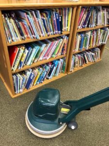 A professional carpet cleaning machine on a commercial carpet next to bookshelves by Heaven's Best Carpet Cleaning in Fargo, ND.