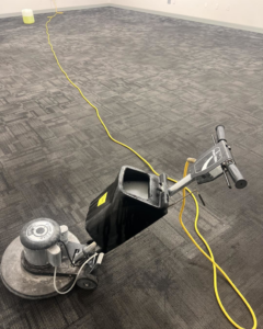 A heavy-duty commercial carpet cleaning machine on a dark carpet by Laredo Carpet Cleaning Services in Laredo, TX.