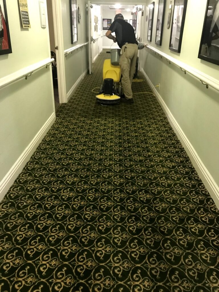 A professional cleaning a patterned commercial carpet in a hallway with a rotary machine by Mark it Clean Carpet & Upholstery Cleaning Long Beach, CA.