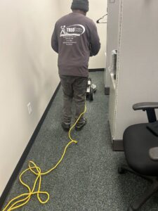 A professional performing commercial carpet cleaning in an office by Treo General Services of North Carolina LLC in Durham, NC.