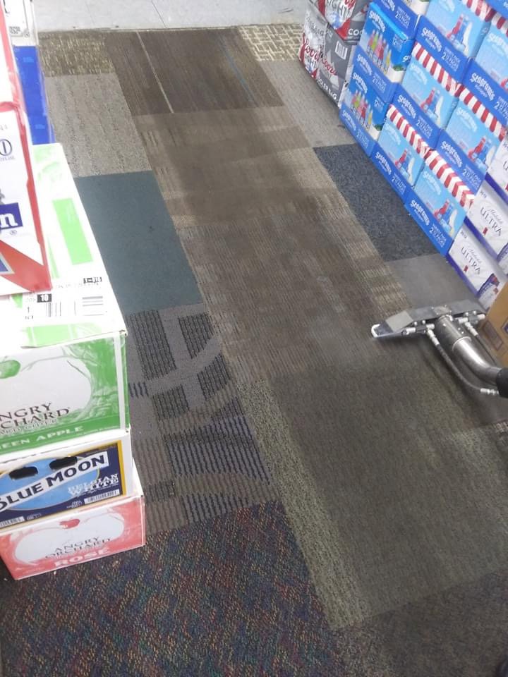 A patterned commercial carpet being cleaned, showing a clean strip next to a dirty section by Bee Clean Carpet Steam Cleaning in Dover, DE.