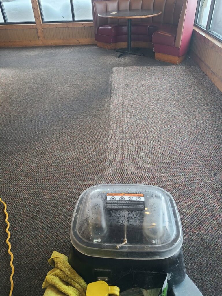 Commercial carpet cleaning in progress at a restaurant, showing a clean/dirty divide by Alaska Floor Care Specialists in Fairbanks, AK.