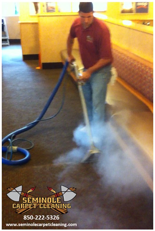 Professional technician performing commercial carpet cleaning in a restaurant by Seminole Carpet Cleaning in Tallahassee, FL