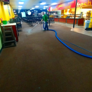 A technician performing commercial carpet cleaning in a large facility by ALL CLEAN America in Baton Rouge, LA.