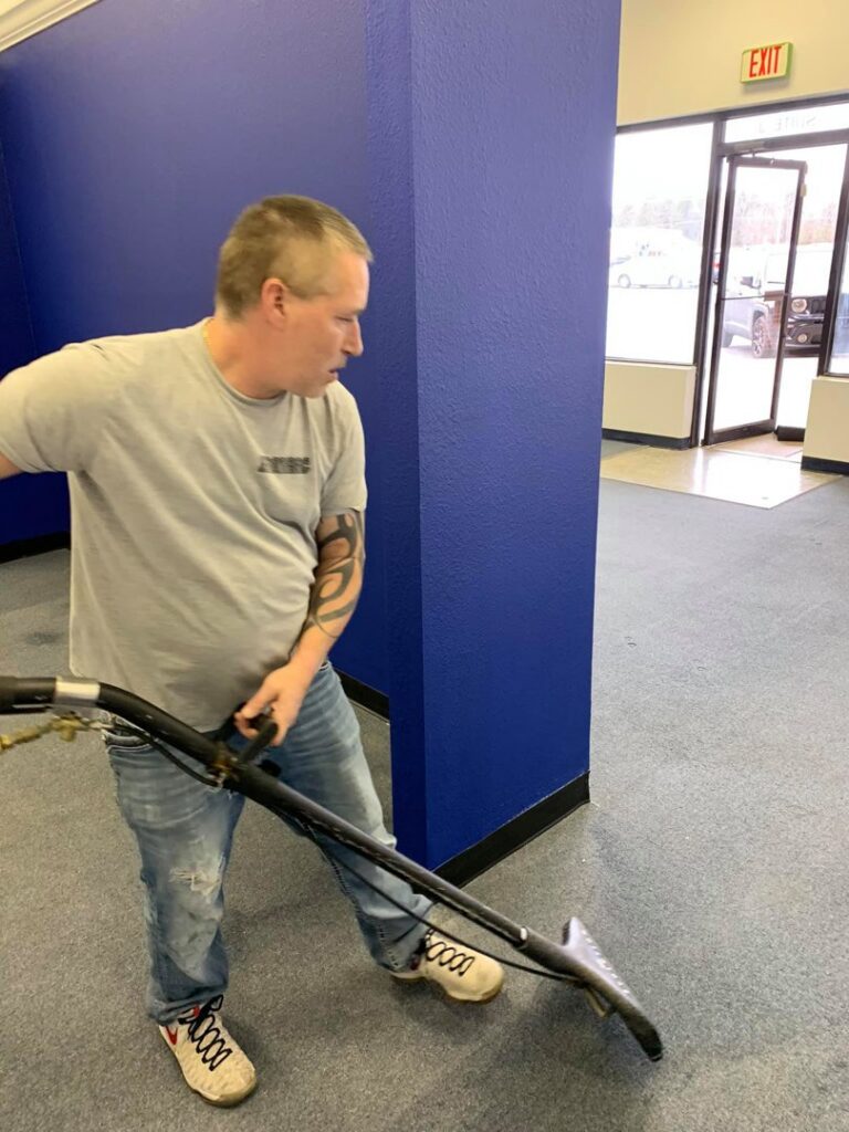 A Promarc Carpet Care technician performing commercial carpet cleaning with a machine in Pine Bluff, AR.
