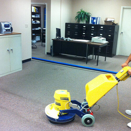 A large rotary scrubber machine cleaning a commercial carpet in an office by Referral Cleaning and Restoration Inc. in Fort Wayne, IN.