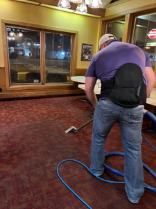 A professional cleaning red patterned carpet in a commercial space by The Steam Master Inc. in Fort Wayne, IN.
