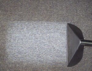 Commercial carpet cleaning in progress, showing a clean strip on a grey carpet by Superior Carpet Cleaning in Greenville, SC.