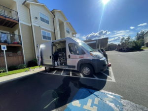 A commercial carpet cleaning service van with equipment parked outside an apartment building by A&g's carpet cleaning service in Vancouver, WA.