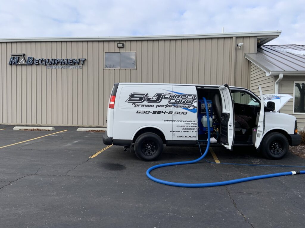 S&J Carpet Care van with hoses extended for commercial carpet cleaning at MAB Equipment Company in Oswego, IL