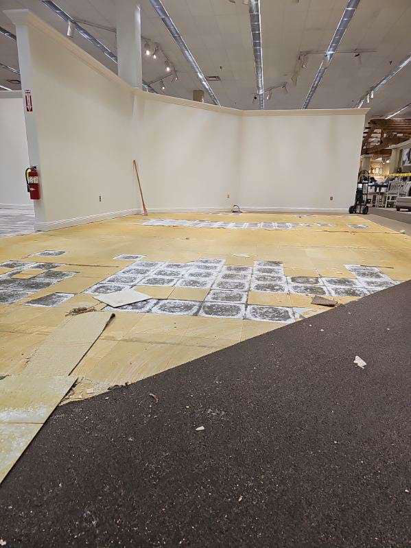 A large commercial floor with old carpet partially removed by Universal Flooring LLC in Las Cruces, NM