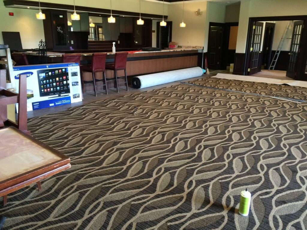 Commercial carpet roll installation in progress in a large room by Branch Floor Covering in Cranston, RI