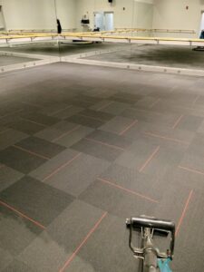A carpet cleaning machine working on commercial carpet tiles in a large studio space by 765 Custom Cleaners in Lafayette, IN.