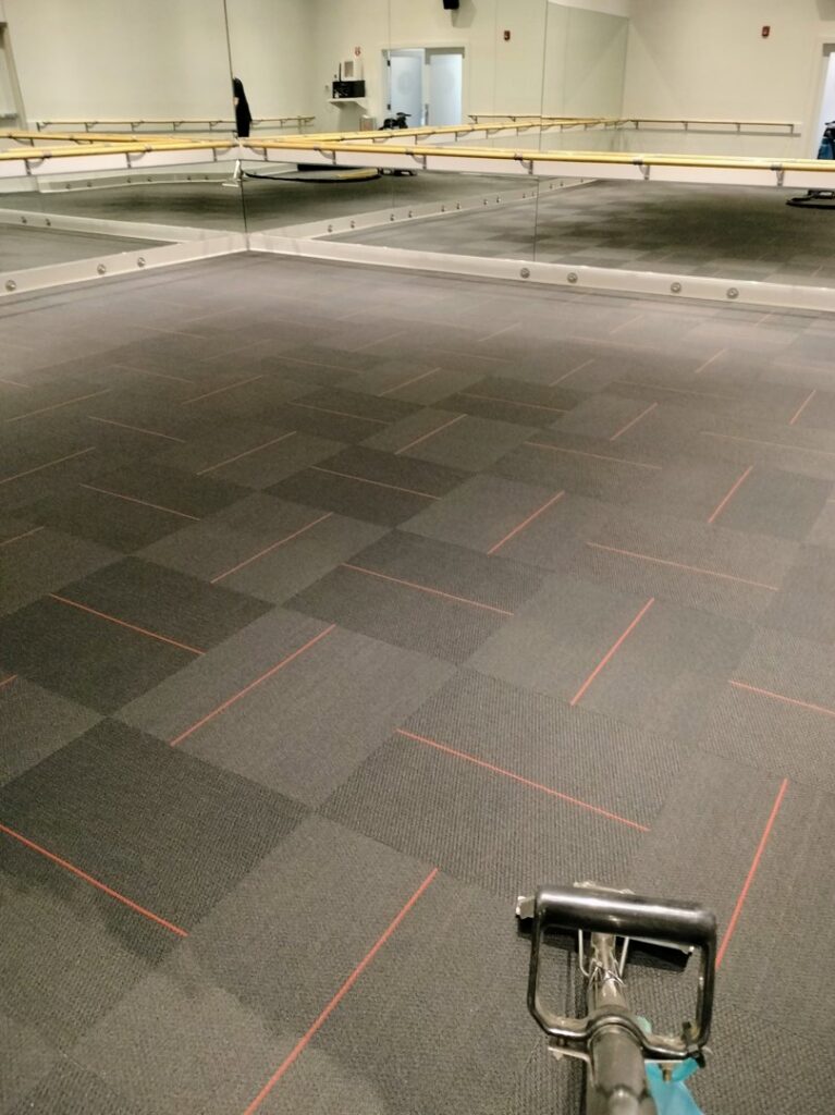 A carpet cleaning machine working on commercial carpet tiles in a large studio space by 765 Custom Cleaners in Lafayette, IN.