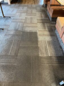 Commercial carpet tiles showing areas of cleaning, indicating a job by Complete Carpet Care in Fort Wayne, IN.