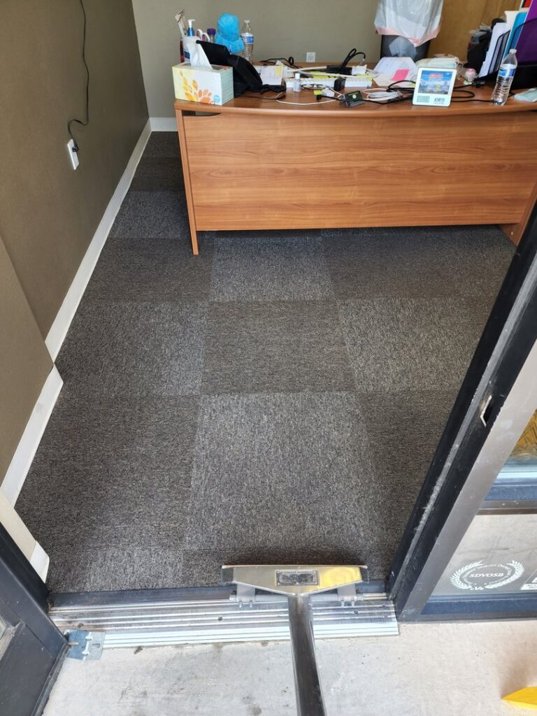 Commercial carpet tiles being cleaned, showing a clear difference between dirty and clean sections by Steamaway Carpet Cleaning in Albuquerque, NM.
