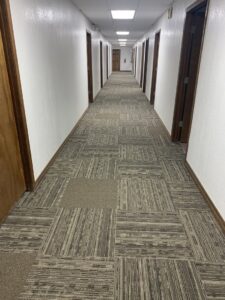 A long commercial hallway featuring newly installed carpet tiles by Carpet Direct Brandon Burley in Tulsa, OK.