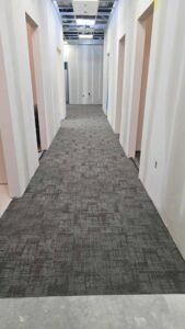Commercial hallway with newly installed grey carpet tiles by Johnson City Flooring & Finish, LLC in Johnson City, TN
