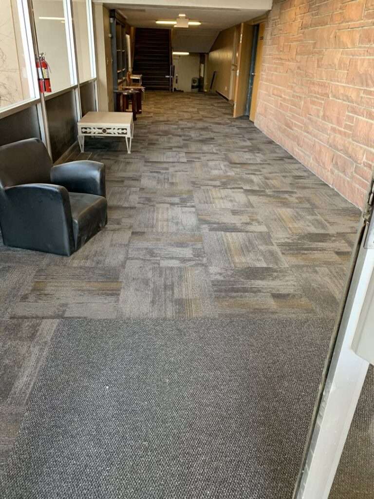 A commercial hallway featuring new carpet tile installation by AguirreFloorz in Colorado Springs, CO.