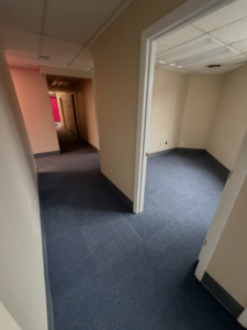 A newly installed commercial carpet tile floor in a hallway and office space by Basics Flooring in Natick, MA.