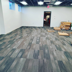 A large commercial space with newly installed grey carpet tiles by Yankees Carpet Inc in Baltimore, MD
