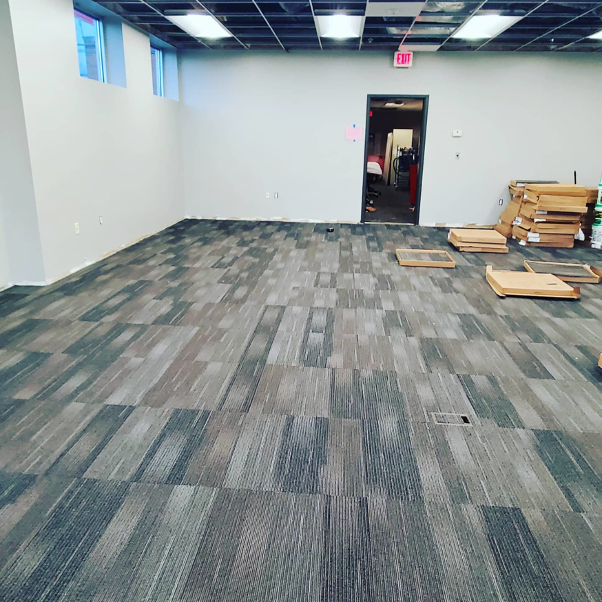 A large commercial space with newly installed grey carpet tiles by Yankees Carpet Inc in Baltimore, MD