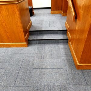New grey commercial carpet tiles installed on stairs and in a hallway, a professional installation by Affordable Carpet & Flooring in Dallas, TX.