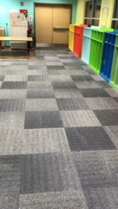 Clean commercial carpet tiles in a hallway, showcasing the type of flooring Elementscarpetcleaning.net works with in Omaha, NE.