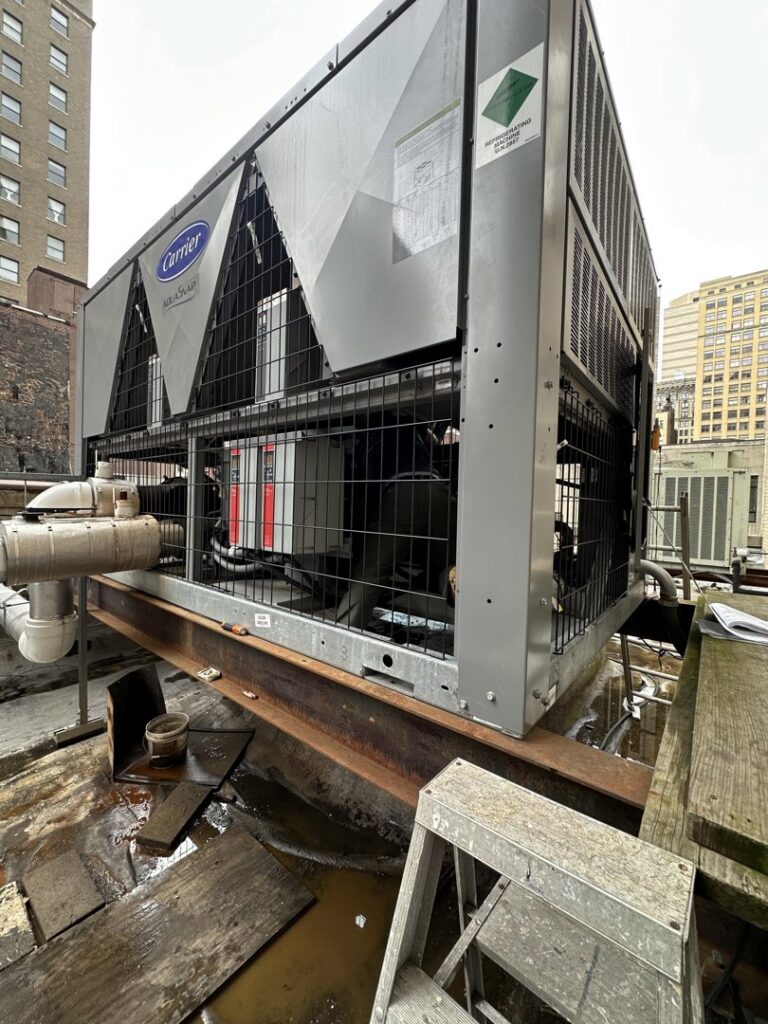 A large commercial Carrier chiller unit on a rooftop, serviced by Green Mechanical LLC in Philadelphia, PA.