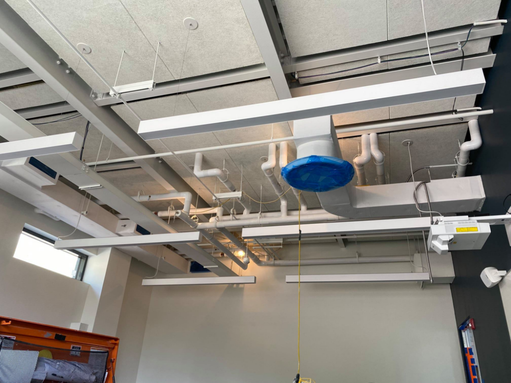 Commercial ceiling with HVAC ductwork, pipes, and lighting installed by North Country Mechanical Insulators in South Burlington, VT.