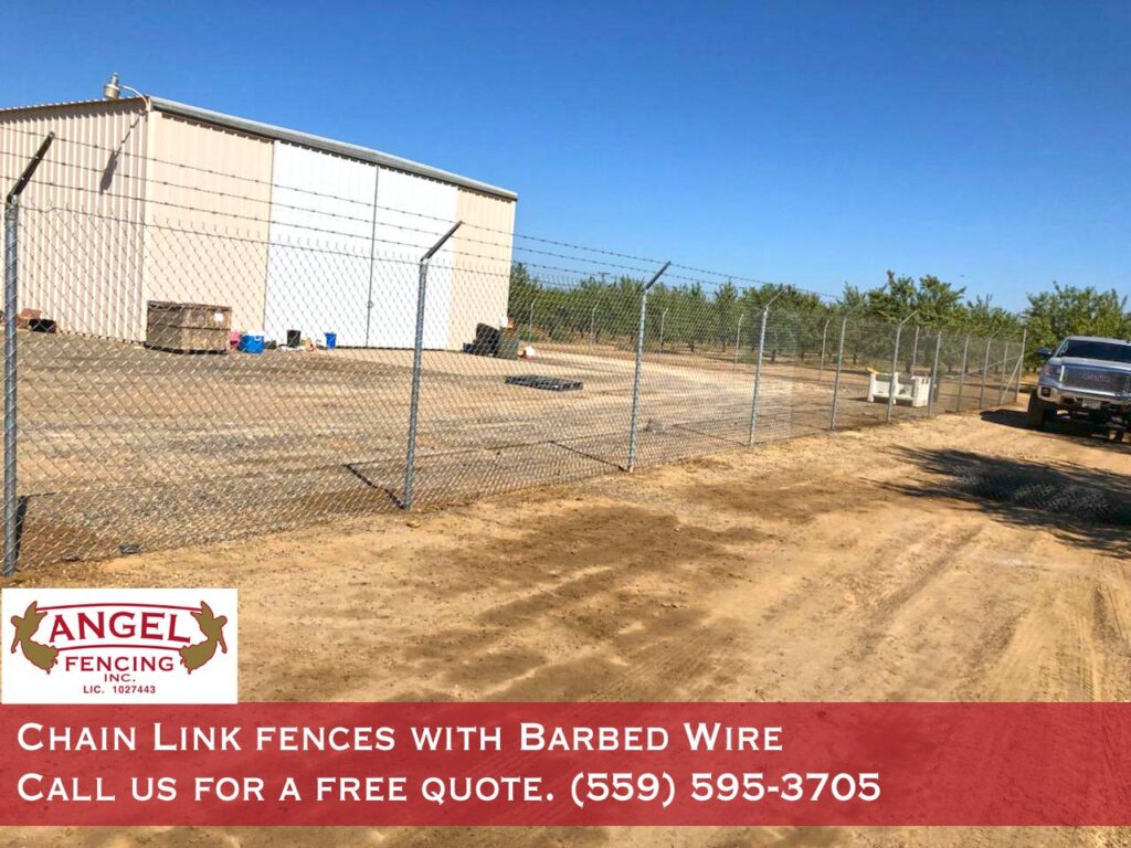 A commercial chain link fence with barbed wire installed by Angel Fencing Inc. in Fresno, CA