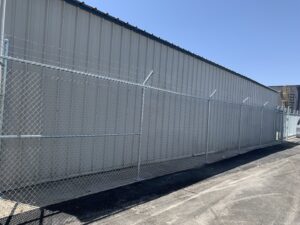 A commercial chain-link fence with barbed wire for enhanced security, installed by G L Fence & Remodeling in Arlington, TX.