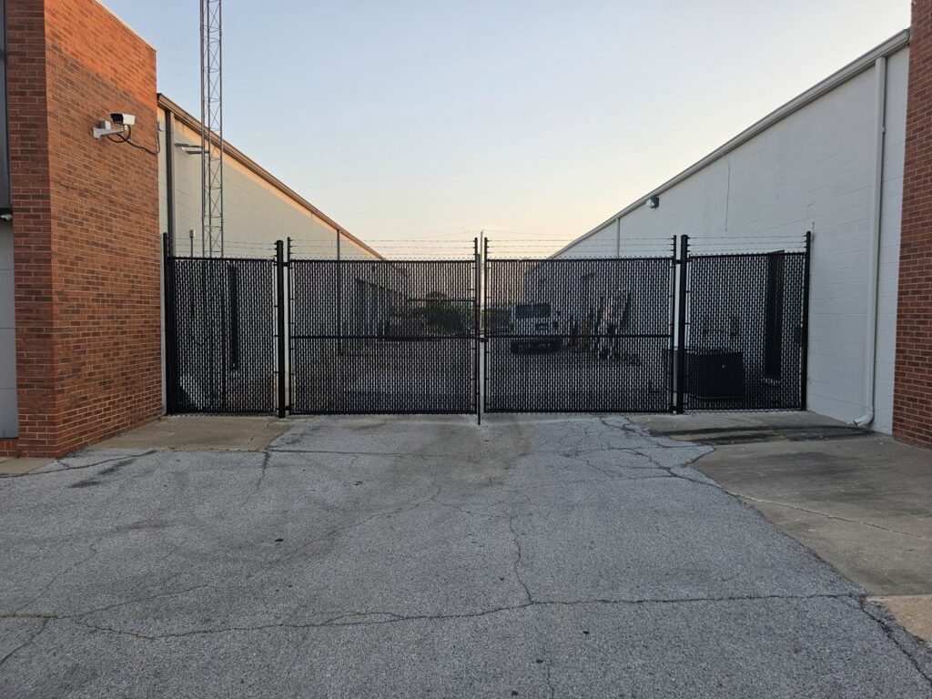 A large commercial chain-link fence with barbed wire installed by Frontline Fence Company in Fulton, NY