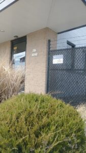 A commercial chain-link fence with privacy slats and barbed wire installed by Northway Fence in Menomonee Falls, WI.