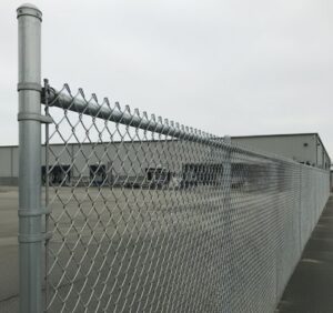 A long chain-link fence providing security for a commercial property by Boost My Home in St. Augustine, FL.