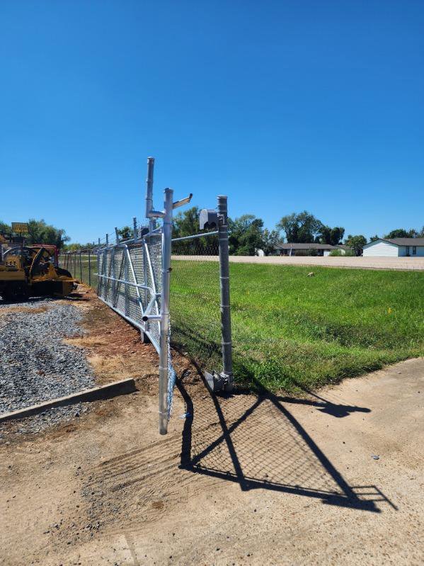 A commercial chain link fence with an open gate installed by Lynch's Lawn & Fence LLC in Bossier City, LA.