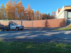 A commercial chain-link fence with privacy slats installed, with a work truck nearby, by Five Star Fence Co. in Anchorage, AK.
